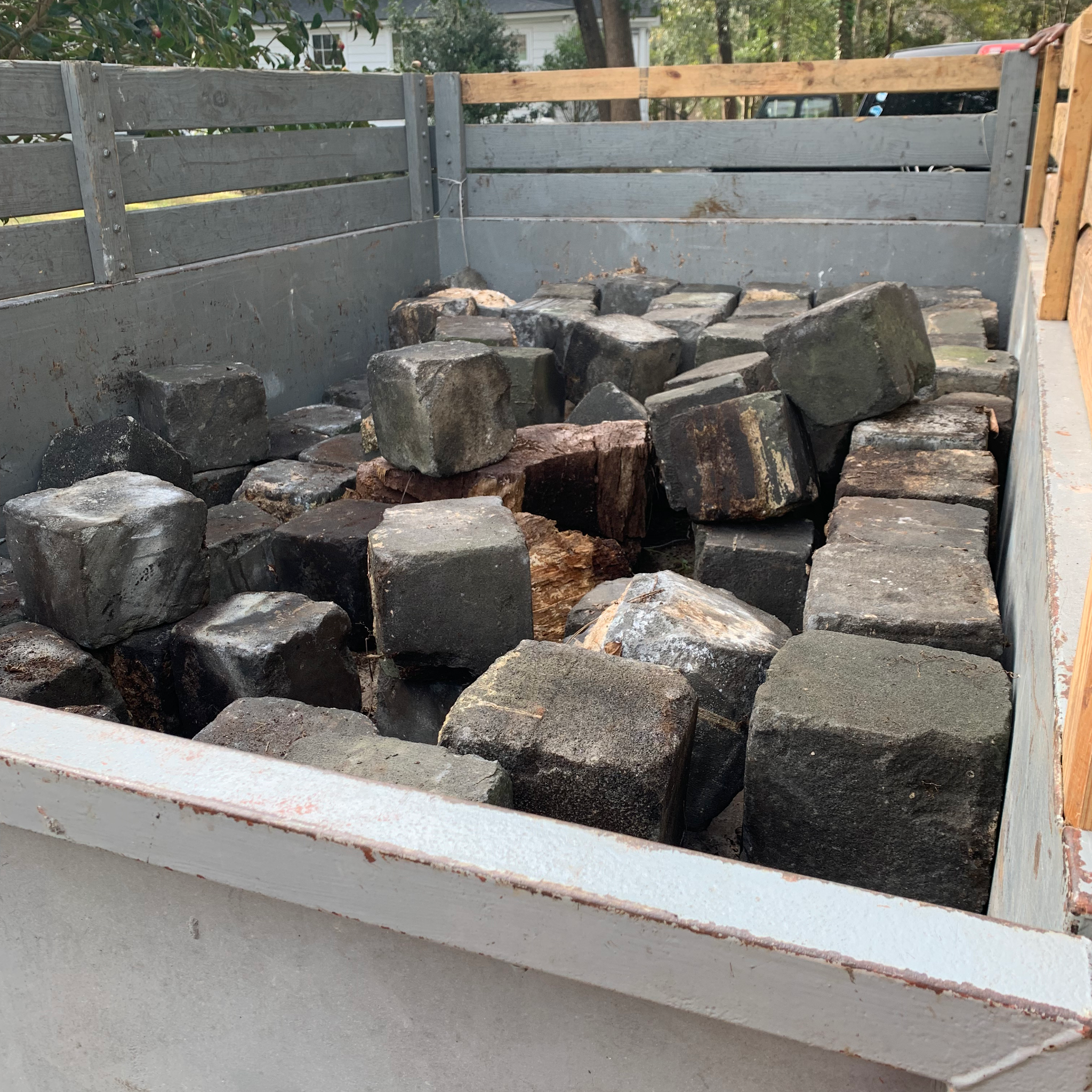 A dumpster loaded with heavy stone blocks